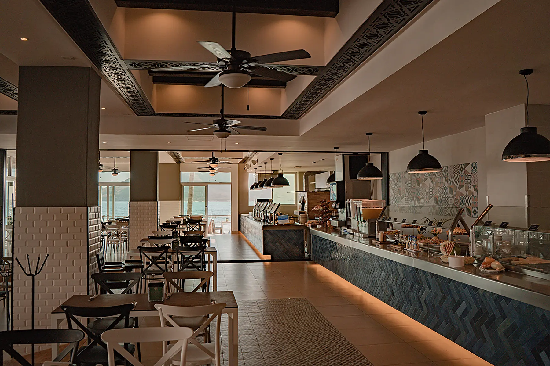 Barra de alimentos, mesas, luminaria del restaurante terraza con vista al mar de hotel oceano palace Mazatlán